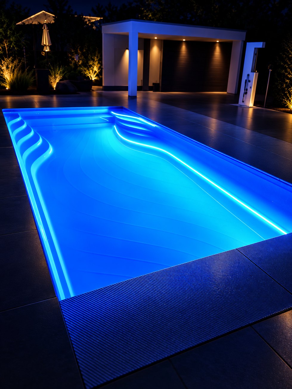 Keramisch zwembad met blauwe LED-verlichting in de avond